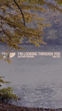 This video features a serene autumn landscape with a calm body of water and trees with yellowing leaves. The camera slowly pans down from the scenic view to a puddle on the ground, reflecting the surrounding environment. Overlaid text identifies the song as 'I'm Looking Through You (Second Version) - TAKE 03' by The Beatles. The audio consists of the band's rock music, creating a contemplative atmosphere. by @thebeatles with I'm Looking Through You (Second Version - Take 3) by The Beatles