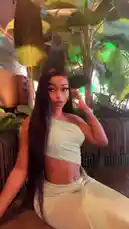 In a stylish, plant-filled lounge, Natasha 💐❤️ showcases her look in a trendy one-shoulder crop top and matching pants. She sips white wine from a large glass, poses confidently, and runs her hand through her long hair, all while the ambient green lighting enhances the tropical, chic atmosphere. by @ohmsnatasha with Original Sound by Contains: Pink Birthday - Nicki Minaj
