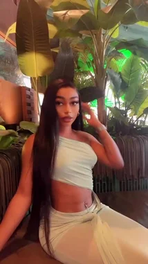 In a stylish, plant-filled lounge, Natasha 💐❤️ showcases her look in a trendy one-shoulder crop top and matching pants. She sips white wine from a large glass, poses confidently, and runs her hand through her long hair, all while the ambient green lighting enhances the tropical, chic atmosphere. by @ohmsnatasha with Original Sound by Contains: Pink Birthday - Nicki Minaj