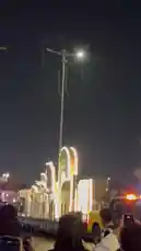 Witness the vibrant energy of Saudi National Day celebrations as performers in traditional white thobes and ghutras dance on a brightly lit parade float. The festive atmosphere is captured from the crowd's perspective, showcasing the cultural pride and joyous spirit of the event. by @wedad_23g with Original Sound by wedad_23g