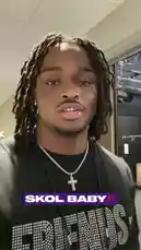 A close-up shot features a Minnesota Vikings player speaking directly to the camera. He is wearing a black t-shirt with 'FRIENDS' in rhinestones and a silver cross necklace. A text overlay reads 'SKOL BABY!!'. The audio consists of a deep, guttural growl. by @vikings with Original Sound by vikings