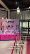 This video offers a glimpse into the exclusive setup of a 'flormar x HOS' makeup masterclass event hosted by Noorah Artist 💄. The scene is set with elegant red ropes, branded backdrops, and professional lighting, creating an atmosphere of sophistication and anticipation for attendees. by @nowaira-11 with original sound