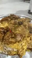 This video offers a close-up view of a delicious-looking biryani dish served on a metal plate. The camera slowly pans across the food, highlighting the rich layers of rice and tender meat. In the background, a person can be heard speaking in Arabic, adding an authentic cultural touch to the scene. by @alafasy81 with Original Sound by alafasy81