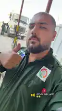 This first-person perspective video offers a glimpse into the daily routine of an Egyptian civil defense worker. The individual, wearing a green uniform adorned with official patches, gives a thumbs-up to the camera while standing near a large white truck, likely a fire or rescue vehicle. The setting appears to be an outdoor work site or base, suggesting a moment of pause during operations. The Arabic text overlay, 'الامور طيبه نشاطالله' (All matters are good, may God bless you), conveys a positive and reassuring message, possibly indicating a successful mission or a safe day. This authentic snapshot provides insight into the professionalism and dedication of emergency services personnel. by @vii35_1 with الامور طيبه نشاءالله by 😭😂