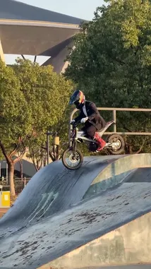 This dynamic clip captures Vepace performing impressive freestyle tricks on his electric dirt bike at a skatepark. He executes a series of jumps and grinds on ramps and rails, showcasing his skills against a backdrop of trees and a large stadium structure. The action is set to energetic rock music. by @vepace with Original Sound by vepace