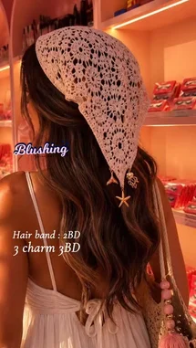 A woman models a delicate pink crochet headscarf adorned with starfish and mermaid charms, styled over long wavy hair. She wears a white spaghetti strap dress and carries a matching pink tassel bag. The setting is a warm, pink-lit boutique, creating a soft, romantic aesthetic. This look is perfect for spring, summer, or boho-chic fashion enthusiasts. by @bx301a with 💖 by Contains: Sex on the Beach - PARTYNEXTDOOR
