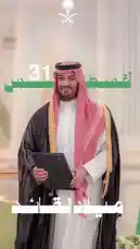 A formal portrait of Saudi Arabia's Crown Prince Salman Bin Abdulaziz, commemorating the Kingdom's National Day. He is dressed in traditional attire, holding a document, with celebratory Arabic text overlaying the image. by @batoolmakeup1 with السعودية العظمى 🇸🇦 by Zied_alswaida