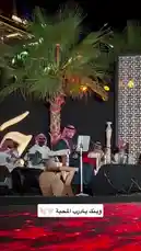 A captivating live performance by a traditional Arabic band during a nighttime cultural event. Musicians dressed in authentic attire play classic instruments like the oud and bendir under warm stage lights, creating an immersive atmosphere enhanced by palm trees and elegant decor. by @jalsahevent with jalsahevent by Original Sound