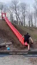 In this dynamic playground scene, Chris Colditz performs a daring stunt involving a long red slide. He throws a black ball down the slide while simultaneously launching himself into a backflip, landing perfectly at the bottom. A blue ball rests nearby on the wood-chip ground. This impressive display of athleticism combines parkour-like movement with playful creativity. by @chriscolditz with Original Sound by chriscolditz