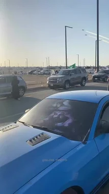 Witness breathtaking aerial acrobatics during a Saudi airshow. Multiple jets perform synchronized maneuvers, leaving trails of white and green smoke against a clear blue sky. Onlookers gather in a parking lot to watch the display, which includes impressive heart-shaped patterns created by the aircraft. This stunning performance showcases national pride and military precision. by @i5lom with Original Sound by i5lom
