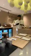 This is a behind-the-scenes look at Sequence Coffee, showing staff preparing for service. The modern café features stylish wooden interiors, a unique yellow cloud-like ceiling fixture, and a well-organized counter with coffee equipment and pastries. by @sequence-coffee with Original Sound by sequence-coffee