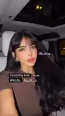 This short-form video features Blushing Botique, a content creator known for her 'Celobatra blue' aesthetic, showcasing her style from inside a car at night. She poses for the camera, highlighting her long black hair, makeup, and accessories. The video captures a moment of personal presentation, emphasizing her signature look. by @bx301a with original sound