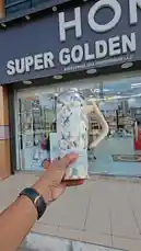 This video offers a close-up look at a selection of stylish tumblers and merchandise, likely from the Super Golden Mobile Phone store. It features a hand presenting various tumblers, including one with a floral design and another in solid pink, highlighting their modern designs and branding. by @super_golden7 with خذا قلبي by حس