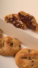 A close-up, mouth-watering display of freshly baked chocolate chip cookies, one broken open to reveal a rich, gooey Nutella filling. Perfectly golden-brown and inviting, these homemade treats highlight delicious textures and indulgent flavors. Ideal for food lovers seeking inspiration for sweet snacks or dessert ideas. by @moladone with original sound