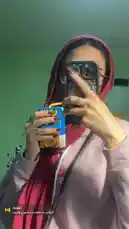In this selfie video, Hana 𓋹 captures her stylish moment. She is seen wearing a pink hijab, a light purple sweatshirt, and glasses, holding a blue carton of milkshake. Her hand gestures add a playful touch to the scene. This authentic lifestyle clip showcases her personal style and everyday moments. by @inxhell with Jadal by لازم أول ما شفتك درت ضهري وهربت
