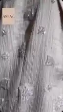 This close-up video showcases the intricate details of the Artal Fashion Eid Collection. The camera slowly pans across a light-colored fabric, highlighting its delicate pleating and elegant floral embroidery. This detailed visual presentation emphasizes the craftsmanship and texture of the garment, offering viewers an intimate look at the design elements. by @artal.street with artal.street by Original Sound