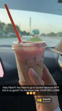 Crazy Town 님이 만든 Butterfly 포함 @rebeccaperi 님이 만든 A hand holds a pink-colored beverage in a clear plastic cup with a red straw, filmed from inside a car. The background shows a road and greenery through the windshield, suggesting a drive during the day. The drink appears to be a layered iced coffee or tea with ice cubes visible. An overlay displays the song 'Butterfly' by Crazy Town playing in the background.