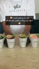 A barista from Sequence Coffee presents four uniquely garnished drinks in branded cups. The presentation is set against a clean backdrop with soft piano music playing, creating an elegant atmosphere. by @sequence-coffee with Life sound🪷🌱 by 🌺✨🐚💗