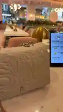 A stylish dining experience unfolds as a tablet displays the 'Sunny Side Up' menu at a beautifully lit restaurant. A hand interacts with the screen, browsing appetizers like 'Lobster Risotto' and 'Crispy Duck'. The elegant table setting features a white quilted handbag, a golden lamp, and a floral menu, capturing the ambiance of a modern, upscale meal. by @miji-bello with Original Sound by miji-bello