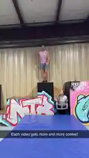 In this intense clip, Chris Colditz attempts a daring parkour flip over a blue mat. He executes a clean backflip but lands awkwardly, tumbling forward onto his hands and knees. A woman in the background watches with her hands clasped, reacting to the near-miss. The industrial setting features graffiti art, highlighting the raw energy of street-style athletic performance. by @chriscolditz with Original Sound by chriscolditz