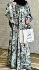 This video features a look from Mohammad Khial, showcasing a beautiful abaya with a grey and black floral pattern. The model wears a matching black hijab and holds a white shopping bag from 'Khial Abaya,' highlighting the brand's elegant designs. by @mohammed_aldrop with Original Sound by Contains: Lola El Banat - Amr Diab & Orange;Amr Diab