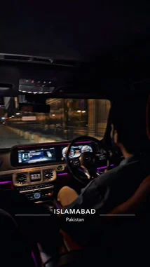 A man drives a luxury SUV through city streets at night. The interior is illuminated with vibrant purple ambient lighting, highlighting the modern dashboard and red leather seats. He navigates the vehicle smoothly while upbeat Punjabi music plays from the car's sound system. by @moazzam with Original Sound by moazzam