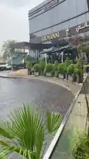 This video provides a stylish tour of Giovanni, a modern lounge and dining establishment. It begins with exterior shots of the sleek building and its landscaped circular driveway before moving inside to showcase the elegant outdoor seating area under large umbrellas. The ambiance is sophisticated and relaxed, perfect for a day out. by @om.louraa with موسيقى by موسيقى