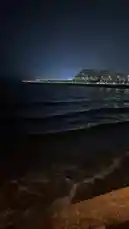 この映像は、暗い夜空の下で静かに打ち寄せる波と、対岸の都市の明かりを捉えています。前景には木製の手すりが見え、視点は海岸沿いから遠くの光景へと伸びます。波のリズムと都市の灯りが織りなす、穏やかな対比が印象的です。 by @i_7x8x with i_7x8x by Original Sound