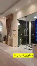 In a luxurious home in Abu Dhabi, a man in traditional Emirati attire surprises another man with a birthday cake featuring his photo and a sparkler. A third man films the moment as they celebrate together. by @bbbbb with Original Sound by Contains: El Youm El Helw Dah - Ahmed Saad