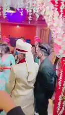 Witness a vibrant moment from Aman Malik's wedding celebration. The groom, dressed in a stunning cream sherwani and white turban, shares a joyful interaction with a woman in an elegant green and blue lehenga. The festive setting, adorned with white floral decorations and purple lighting, captures the essence of a traditional Indian wedding reception. by @officialaman08 with Original Sound by Contains: Laavan Tere Naal - Gagan Kokri