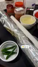 A close-up tour of the ingredients for a chicken dish by Abdulrahman Al-Munif. The video displays raw chicken pieces, fresh vegetables like tomatoes and green chilies, and a collection of pre-measured spices in labeled containers, all laid out on a kitchen counter. by @mr.mneifi with بنضعف صدقوني by Sn : ee-oee