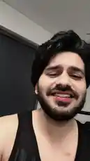 A man with dark hair and a beard, wearing a black tank top, smiles and sings directly into the camera. He moves his head and body slightly while performing. by @dsunmusic with Original Sound by dsunmusic