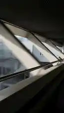A stylish woman in a long patterned coat and heels walks through a modern architectural space with geometric designs. The video showcases details of her outfit, including a distinctive brooch and the texture of her coat, culminating in a full-body shot that highlights her confident stride and the design of the environment around her. by @moonlight_q6r with Original Sound by moonlight_q6r