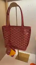 A close-up showcase of a red Goyard Mini Anjou tote bag with its signature monogram pattern and matching pouch. A hand holds up a receipt, revealing the price and installment payment option via Tabby. This video highlights the product's details and purchasing information. by @lussowatches with Original Sound by lussowatches