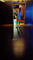 A stylish figure walks through a vibrant, dimly lit lounge or nightclub. The person, wearing a distinctive patterned shirt, red shorts, and white sneakers, moves confidently past a glowing neon sign and under a chandelier before entering a larger dance floor area filled with colorful lights and other patrons. The atmosphere is energetic and modern. by @managergxcci with Still Talkin' by Eazy-E, The D.O.C, Ice Cube