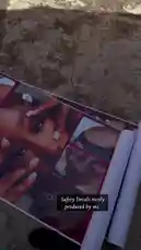 This video provides a close-up, step-by-step view of a person unrolling a promotional banner for 'Beauty Plus Studio.' The banner features images of manicured hands and lists services such as Nails, Pedicures, Lashes, Piercings, and Tattoos. The camera follows the banner as it unfurls across a concrete floor, offering a clear look at the design and layout of the advertisement. by @naa.ayele911 with Don't Play With Me by Gabzy
