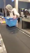 In this candid clip, Lena is seen at a checkout counter placing her blue shopping basket onto the conveyor belt. She wears a light-colored puffer jacket with the hood up and a baseball cap, appearing focused on organizing her items. The setting is clearly a supermarket, with other shoppers and store fixtures visible in the background. by @lenawolf2006 with Original Sound by lenawolf2006