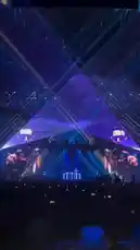 Experience the electrifying atmosphere of a Tiesto live concert. This dynamic performance features a massive stage with dazzling blue laser lights creating intricate geometric patterns, large screens displaying the DJ, and a sea of fans holding up their phones. The energy is palpable as the music builds, showcasing a spectacular light show that transforms the venue into a futuristic dance floor. by @tiesto with Original Sound by tiesto