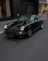 This video provides a comprehensive, cinematic walkthrough of a stunning black Porsche 911 parked on a city street. The camera moves around the car, highlighting its iconic front grille, round headlights, sleek body lines, and distinctive wheels. The glossy black paint reflects the urban environment, emphasizing the vehicle's pristine condition and timeless design. This is a pure showcase of automotive beauty and engineering. by @two with Original Sound by two