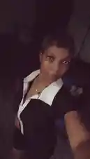 In a dimly lit room, Çēçê takes a selfie, showcasing her style with a black top featuring a contrasting white collar. She makes various poses and gestures for the camera, including pointing and flashing a peace sign, all while a vibrant Afrobeat track plays in the background. by @sh-eila2026 with Baba by Hotkeed