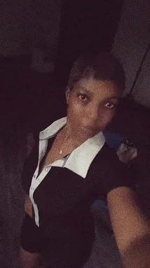In a dimly lit room, Çēçê takes a selfie, showcasing her style with a black top featuring a contrasting white collar. She makes various poses and gestures for the camera, including pointing and flashing a peace sign, all while a vibrant Afrobeat track plays in the background. by @sh-eila2026 with Baba by Hotkeed