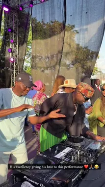 DJ SPINALL commands the stage at an outdoor music festival, showcasing his skills on a Pioneer DJ setup. Surrounded by a lively crowd, he performs under vibrant stage lights, creating an energetic atmosphere. by @djspinall with original sound