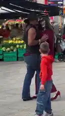 A couple performs an intimate tango on the pavement outside Uxbridge Underground station in London. Dressed in stylish attire, they dance closely amidst the urban backdrop of shops like Popeyes and market stalls, creating a captivating street performance. by @uk-gos with Original Sound by uk-gos