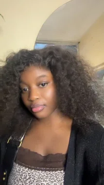 In this close-up shot, Bijou_store showcases her voluminous curly hair and a stylish leopard print top with a brown lace-trimmed bodice. She smiles warmly at the camera, presenting a confident and polished look. by @kebsdiop29 with Original Sound by kebsdiop29
