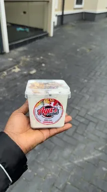 Giftedonye🦋 showcases Aga's Parfait, a zero-fat yogurt product, held in hand against a paved outdoor backdrop. The container features a colorful label with 'ZERO FAT' and 'FRESH SALAD' clearly visible, suggesting a healthy snack option. by @giftedonye22 with giftedonye22 by Original Sound