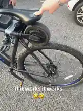 A person demonstrates a creative, albeit questionable, modification to a bicycle. They have attached a small motor to the seat post, seemingly attempting to create a self-propelled seat. The text overlay 'If it works it works' suggests a humorous, experimental approach to this unconventional upgrade. by @uk-gos with Original Sound by Contains: Favorite Place - Ryan Reed