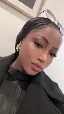 In this close-up look, Dhikrot 💗 showcases her elegant style featuring a sleek black headwrap, delicate gold flower earrings, and chic sunglasses perched on top. She wears a textured black ruffled top, creating a sophisticated and modern aesthetic. This stylish moment captures a fashion-forward vibe perfect for inspiration. by @miji-bello with Lailo by Adekunle Gold