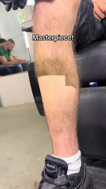 A close-up shot captures a person's leg with a unique, artistic haircut design. The word 'Masterpiece!' is displayed on screen, highlighting the creative and bold nature of the grooming style. by @uk-gos with Original Sound by Contains: Get a Job - KCK Mixes