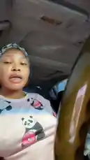 In this candid car vlog, Big Erima is seen sitting in the driver's seat of her vehicle during the day. She wears a distinctive pink t-shirt adorned with cartoon pandas holding donuts and a black-and-white patterned headwrap. Throughout the clip, she speaks directly to the camera, gesturing with her hands as she shares her thoughts, creating an intimate and personal atmosphere. by @eboggar1 with Original Sound by eboggar1