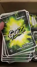 This close-up video showcases a stack of 'GenZ' branded cards with vibrant green and yellow holographic designs. The camera pans across the shimmering surface, highlighting their collectible nature and modern aesthetic. by @pack.d with Thinking Out Loud by Rimzee, Young Adz